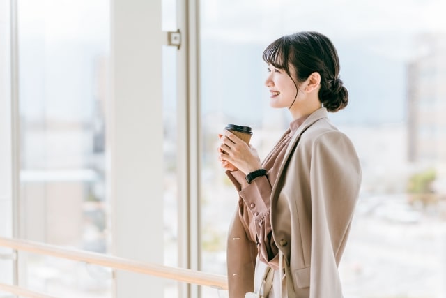 冬にコーヒーを飲んであったまっている女性